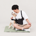 Load image into Gallery viewer, Black bottle bag worn crossbody beside a dog on a warm neutral background