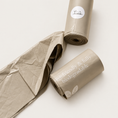 Load image into Gallery viewer, Waste bag rolls and open bag detail on a pale neutral background

